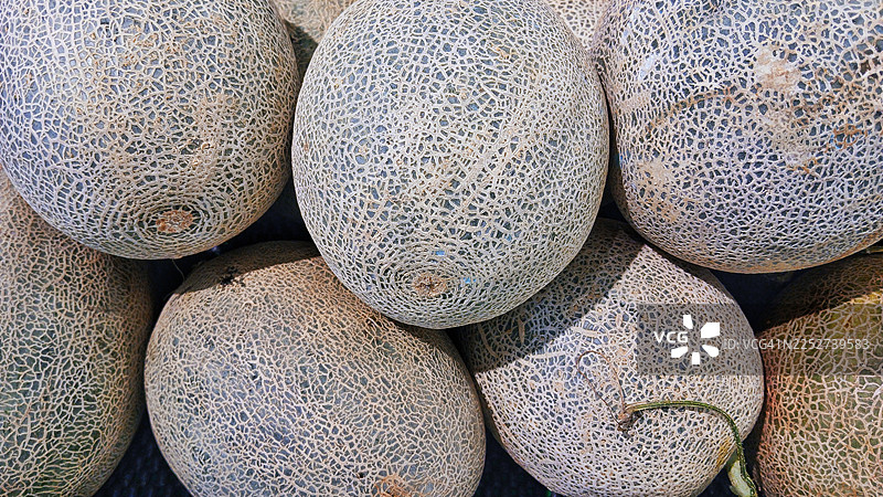 超市货架上堆放的哈密瓜图片素材