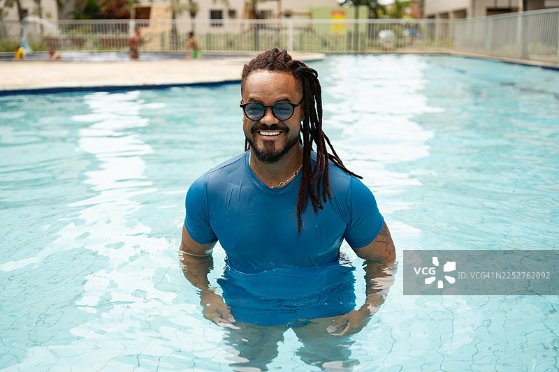 一个留着脏辫的非洲裔男子在游泳池里图片素材