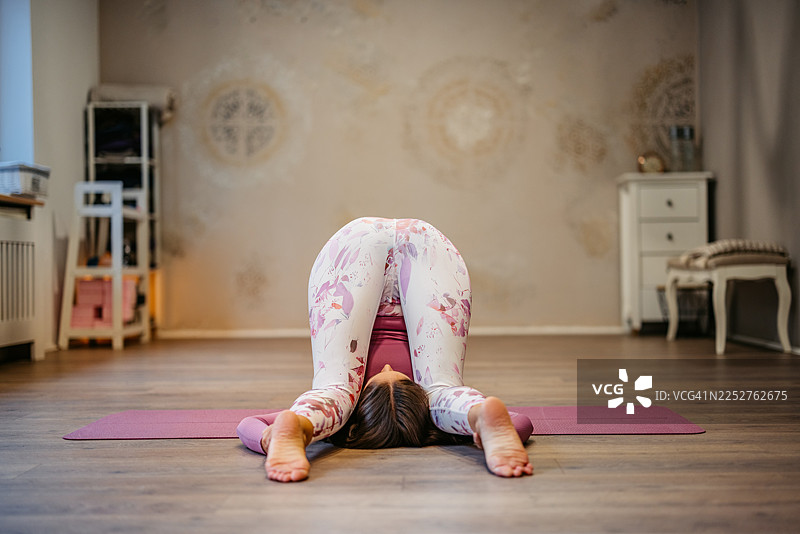 年轻女子在室内瑜伽馆练习犁式瑜伽图片素材