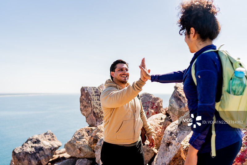 情侣登山时击掌庆祝图片素材