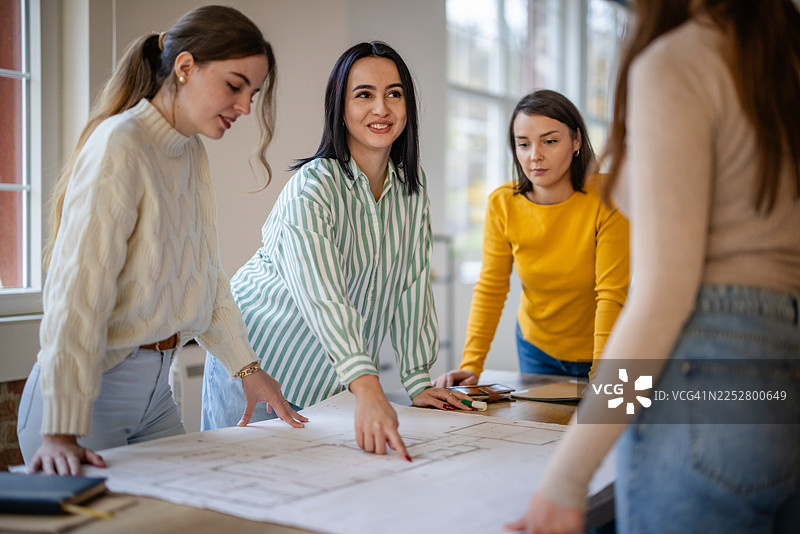 工作时间内，团队成员在明亮的办公室空间讨论项目计划图片素材