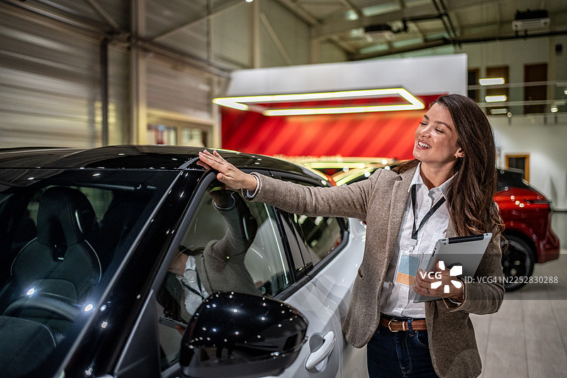 汽车销售员在汽车经销商处展示新款车型图片素材