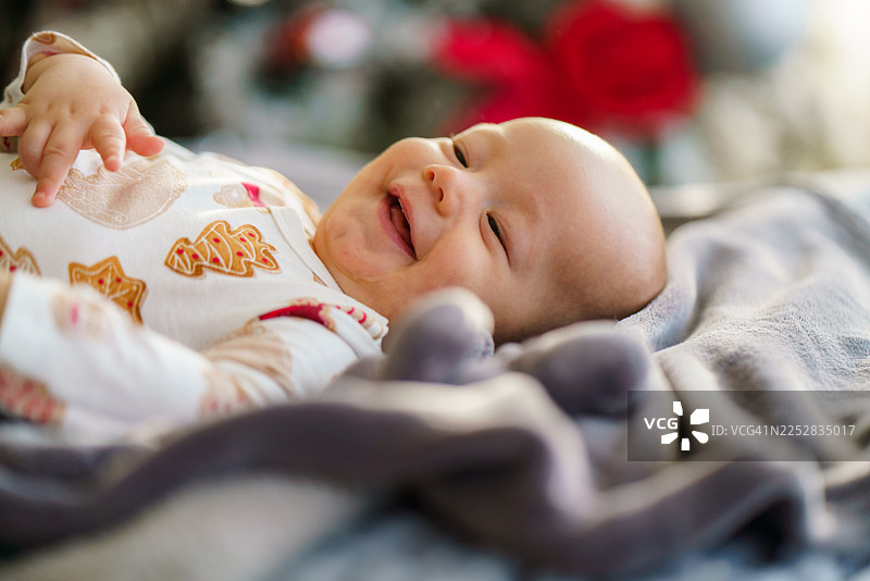 穿着姜饼人圣诞睡衣的快乐宝宝在微笑。图片素材