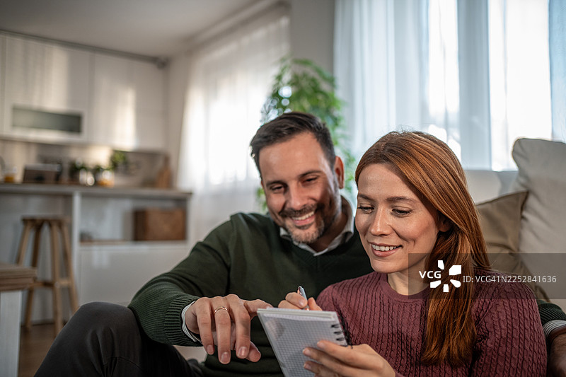 一对快乐的夫妇正在为未来书写财务计划图片素材