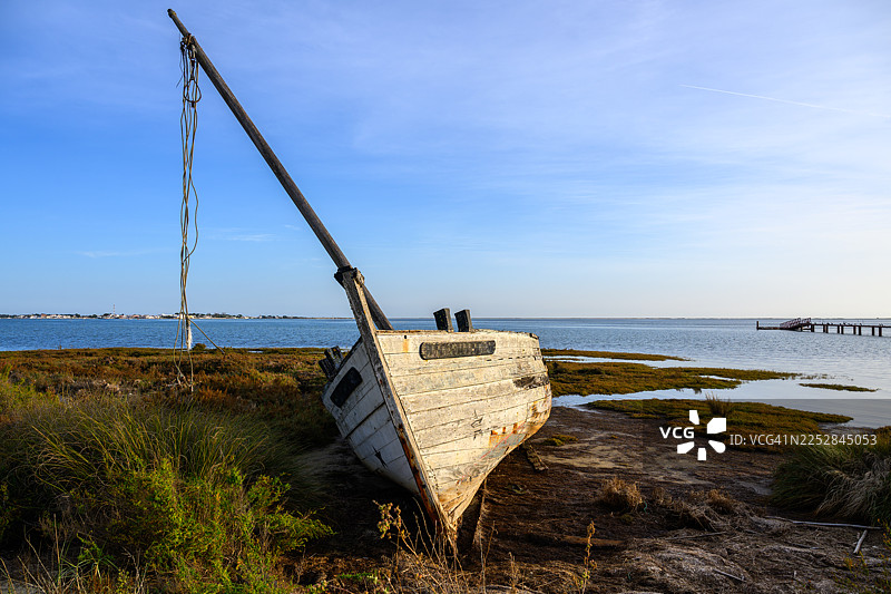 葡萄牙阿尔加维，福尔摩沙河口国家公园内，一艘废弃的渔船在日落时分图片素材