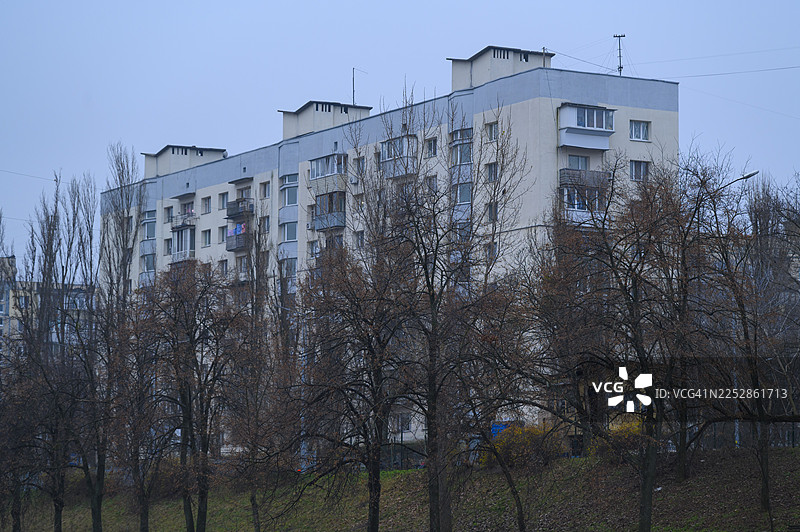 苏联时期的住宅楼，身后是光秃秃的树木图片素材