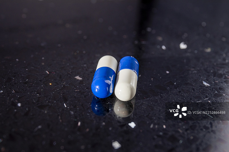 多西环素负荷剂量 - 两个多西环素胶囊放在深色背景上图片素材