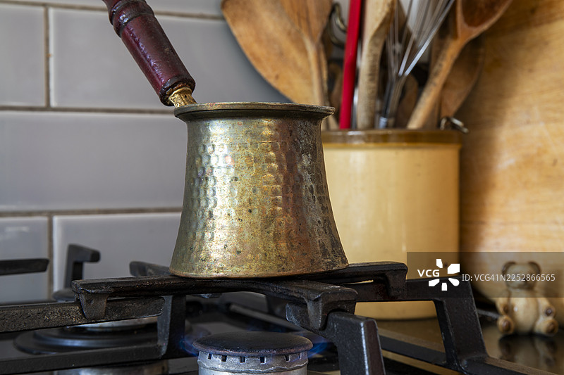 土耳其咖啡加豆蔻 - 在家庭厨房的燃气灶上加热的 ibrik图片素材