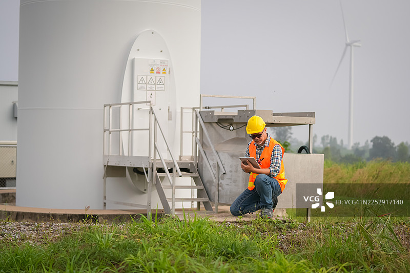 风力涡轮机技术人员在可再生能源现场检查设备，工业景观，户外视角，可持续实践图片素材