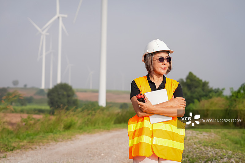 风能工程师在户外专业场景中监督农村风光下的风力涡轮机安装图片素材