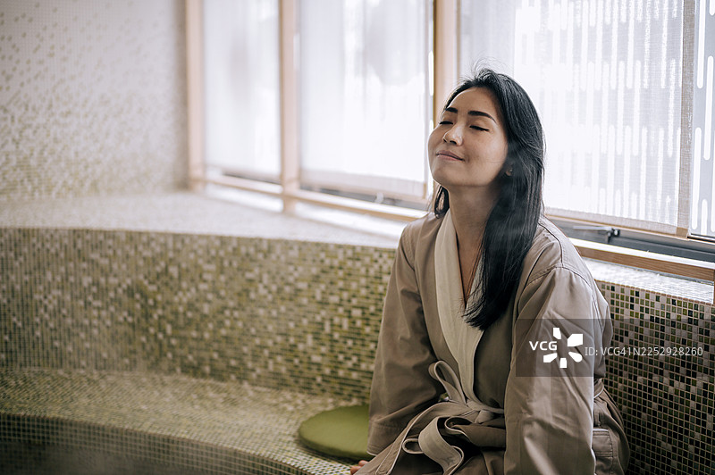 亚洲女性在水疗养生期间在蒸汽房放松图片素材