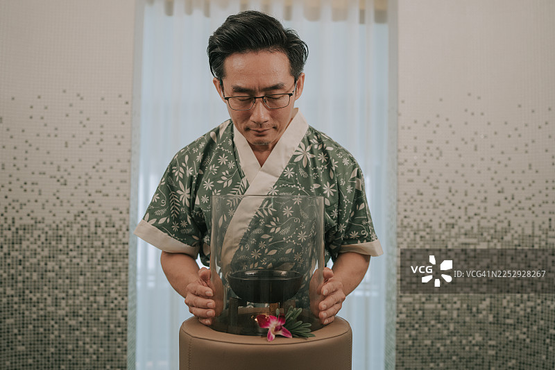 亚洲男性在水疗中心使用精油扩散器进行芳香疗法仪式图片素材