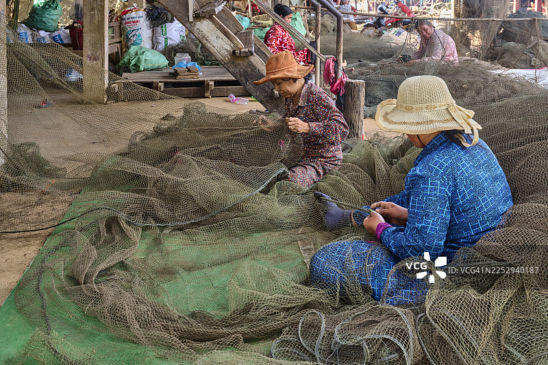 柬埔寨妇女正在修补渔网图片素材
