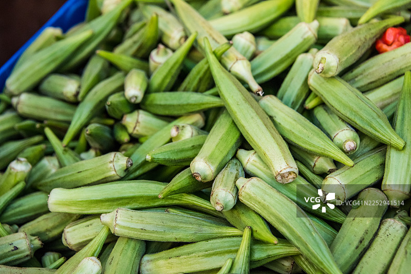 市场摊位上待售的新鲜秋葵堆图片素材