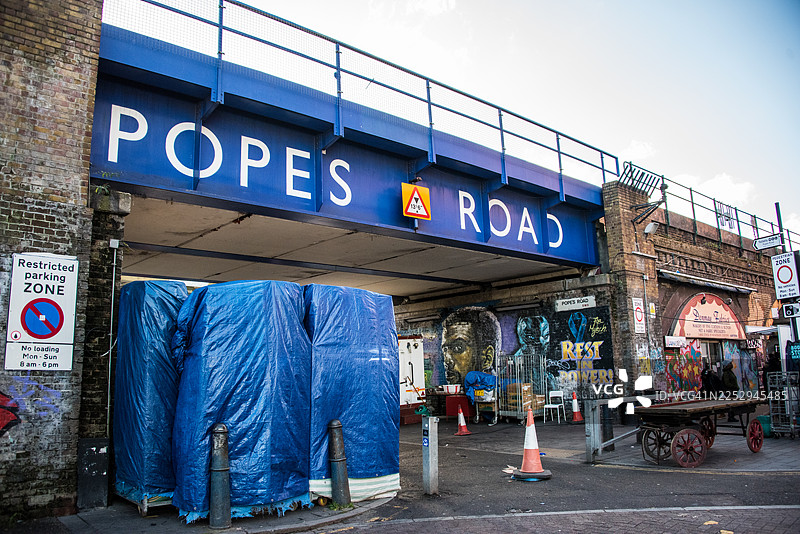 伦敦布里克斯顿的教皇路铁路桥和市场摊位图片素材