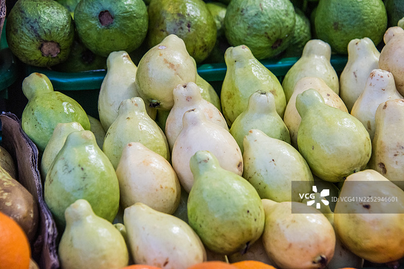 市场摊位上堆放着新鲜的白色番石榴图片素材