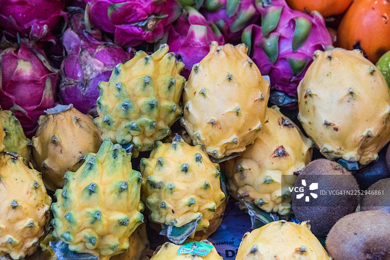 市场摊位上的黄龙果和猕猴桃图片素材