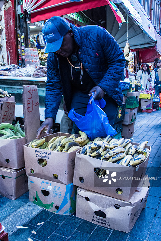 交易员在户外市场整理香蕉箱图片素材