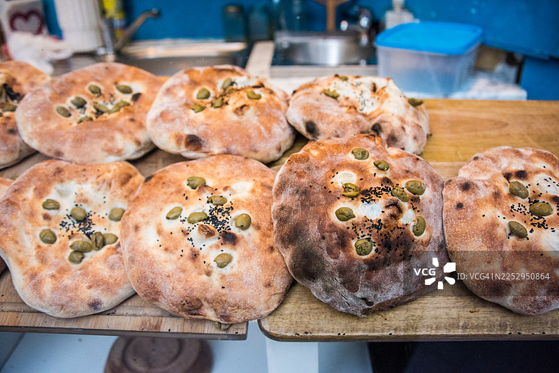 市场上的圆形扁面包配绿橄榄图片素材