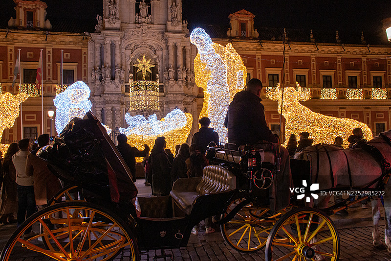人群在塞维利亚圣特尔莫宫前拍摄灯光璀璨的耶稣诞生场景图片素材