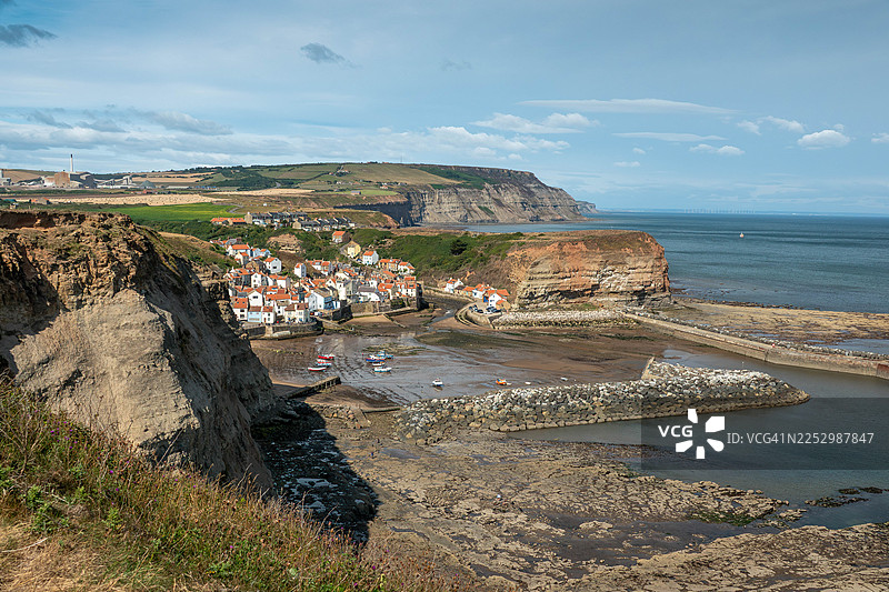 约克郡海岸。英格兰、英国惠特比以北。远处是风景如画的渔村斯泰斯。图片素材