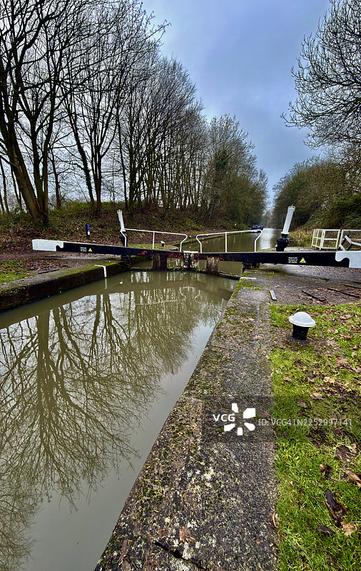 哈顿的顶部船闸，展示了拖曳小径、运河上的步行桥以及树木成荫的景象图片素材