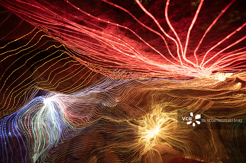 带有纹理的深色背景上的红色和黄色抽象光效图片素材