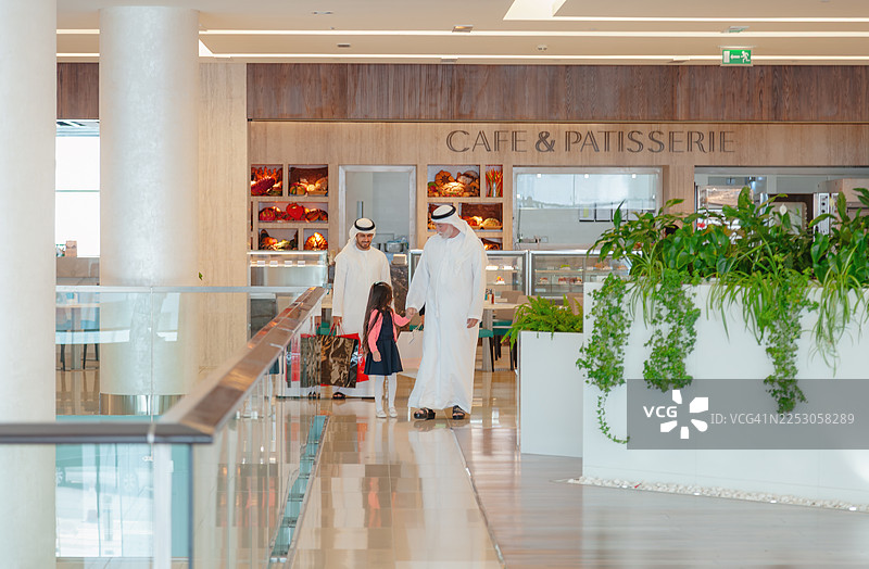 中东三代家庭在现代购物中心室内一起行走图片素材