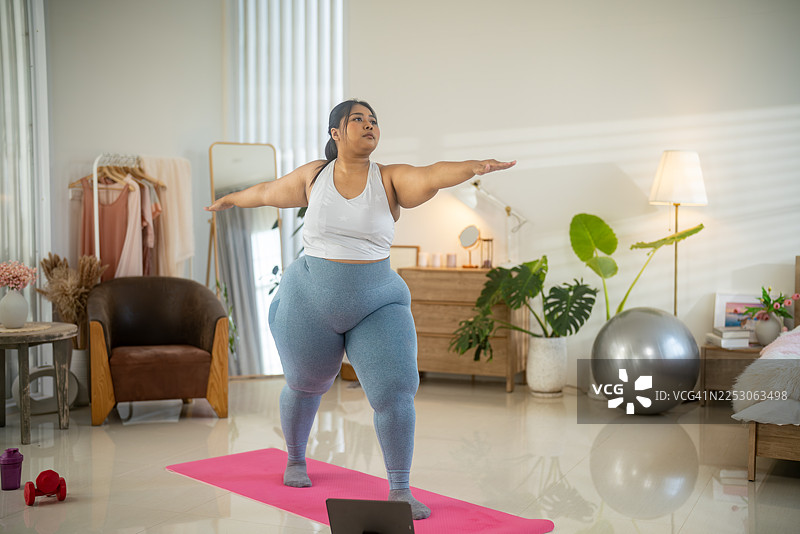 居家瑜伽，丰满女性练习战士二式图片素材