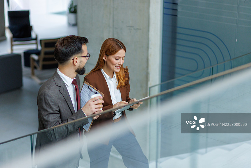 商务人士在楼梯上边走边讨论工作图片素材