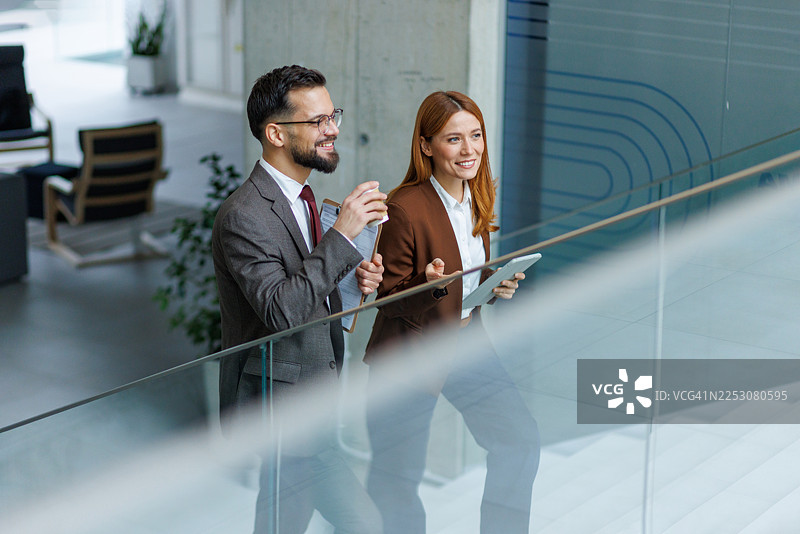 商务人士同事们在现代办公室里走楼梯图片素材