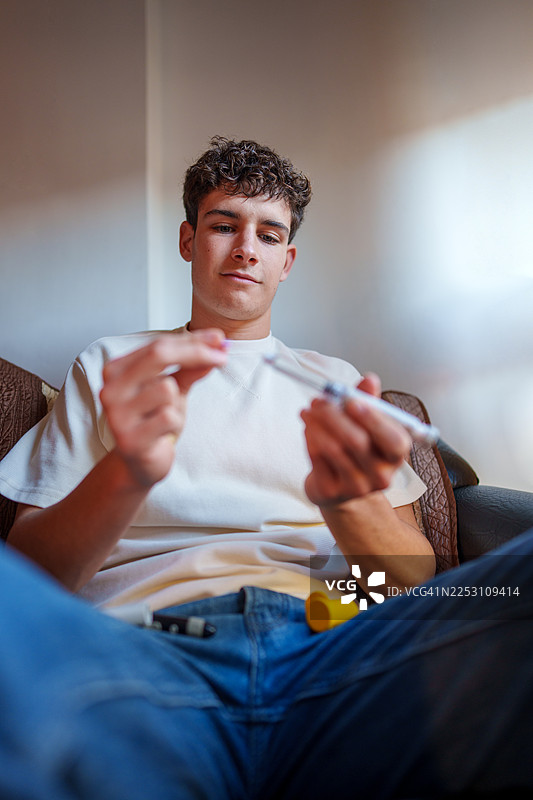 年轻男子准备注射胰岛素治疗糖尿病图片素材
