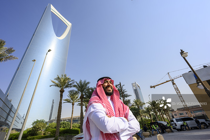沙特男子微笑着站在王国中心摩天大楼前图片素材