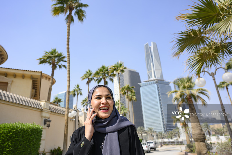 一位穆斯林妇女在利雅得街头用手机交谈图片素材
