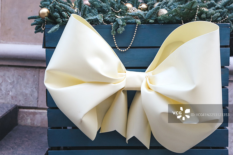 城市街道节日装饰，带有圣诞花环、花彩带和粉奶油色系带蝴蝶结图片素材