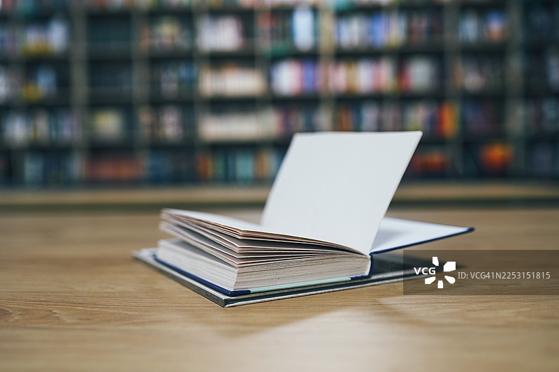 一本打开的书放在图书馆的木桌上图片素材