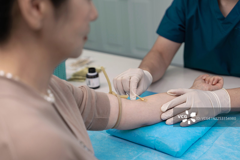 特写：一名护士、医生或医疗技术人员戴着手套在医院采集患者的血样。图片素材