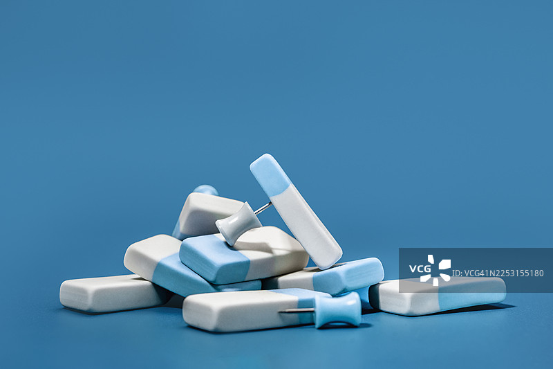 一堆橡皮擦和文具钉。蓝色单色物品图片素材