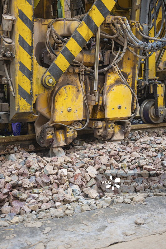 正在使用的建筑大型机械。可见碎石和黄黑标志，压实机在德国卡尔夫区阿尔滕格施泰特赫尔曼黑塞的铁路旁图片素材