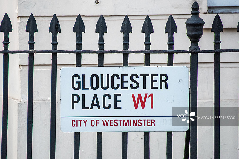 铁栅栏后面的格洛斯特广场路牌图片素材