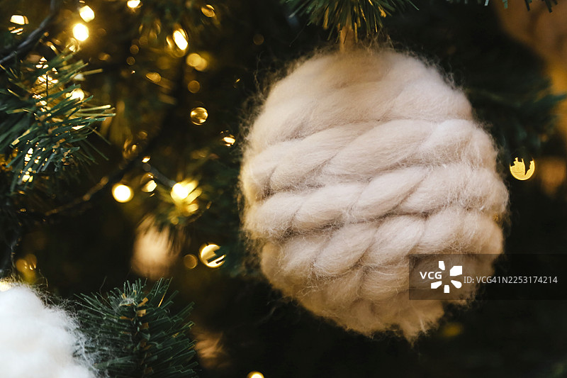新年树，装饰有手工制作的奶油色毛毡和羊毛针织的圣诞球和装饰品图片素材