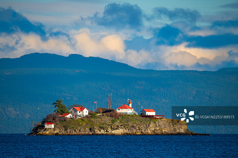 加拿大不列颠哥伦比亚省登曼岛的铬岛灯塔，配有美丽的云彩图片素材