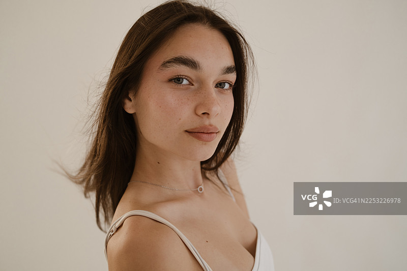 阳光下，一位肌肤洁净湿润的女性的特写肖像图片素材