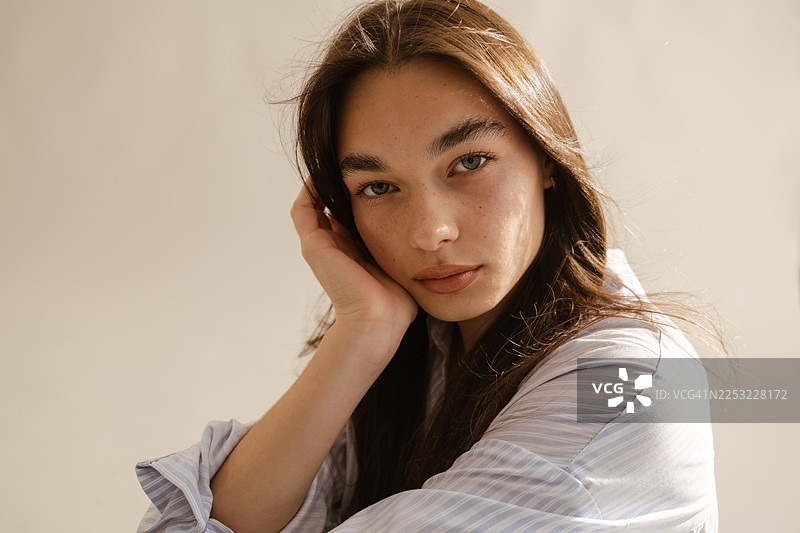 阳光下，一位皮肤洁净湿润的女性的特写肖像图片素材