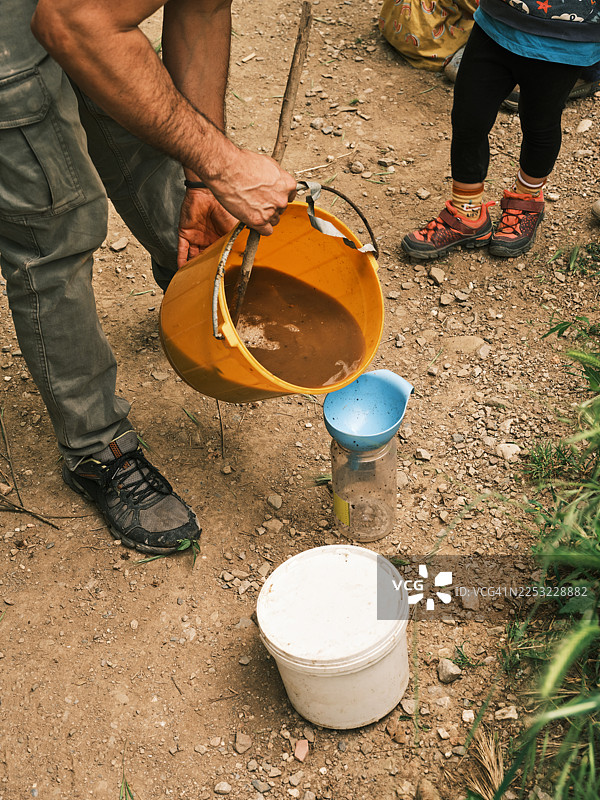 将液体混合物倒入户外的捕虫器中图片素材