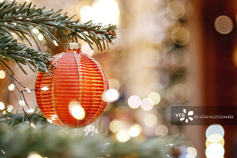 圣诞树装饰精美，挂有橙色工艺品饰品、闪光和发光花环图片素材
