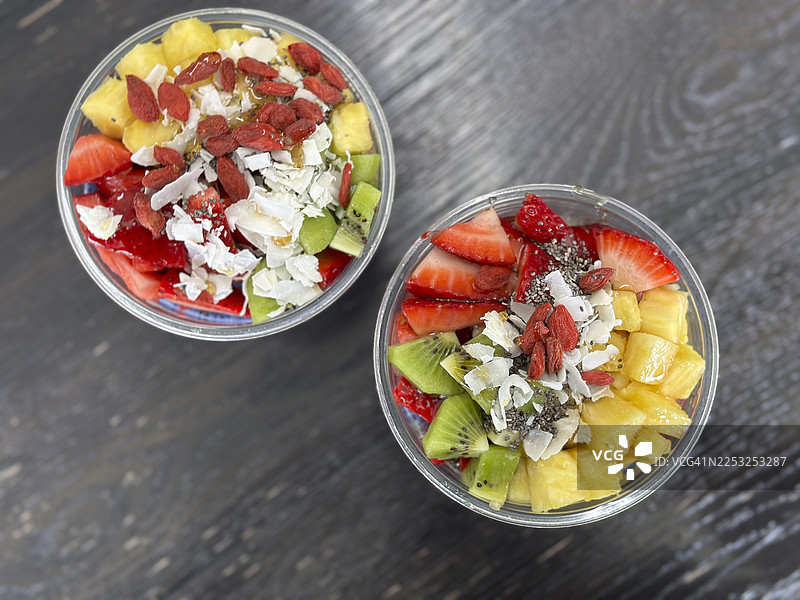 透明杯中的巴西莓碗，配有新鲜水果、奇亚籽和格兰诺拉麦片图片素材