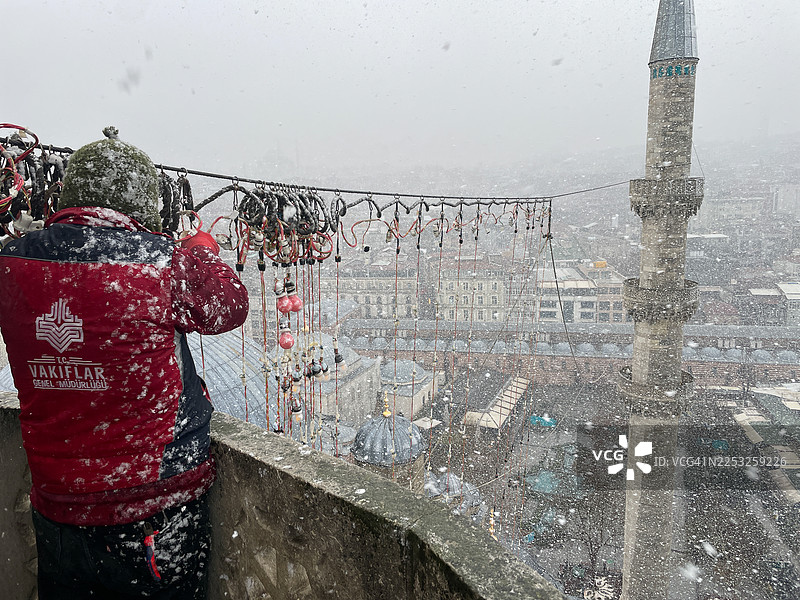 工人们在土耳其伊斯坦布尔新清真寺的雪下安装马哈亚灯图片素材