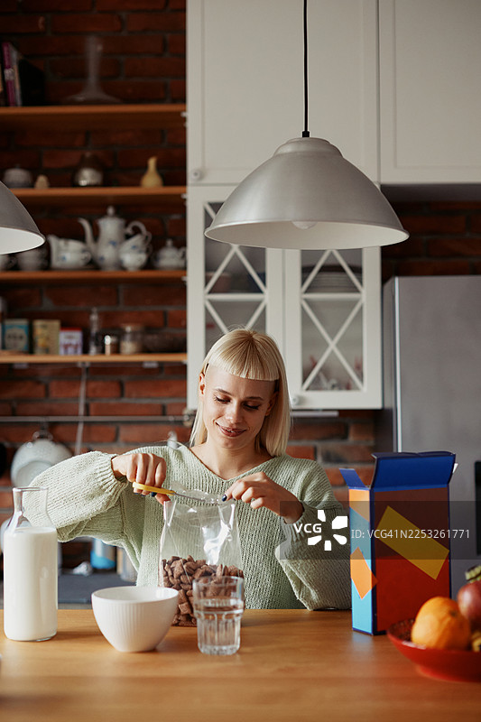 年轻时尚女性在家享用早餐麦片和新鲜水果的晨间日常图片素材