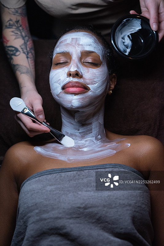 一位放松的黑人女性正在水疗中心享受滋养面膜，享受美容和自我护理的乐趣。图片素材